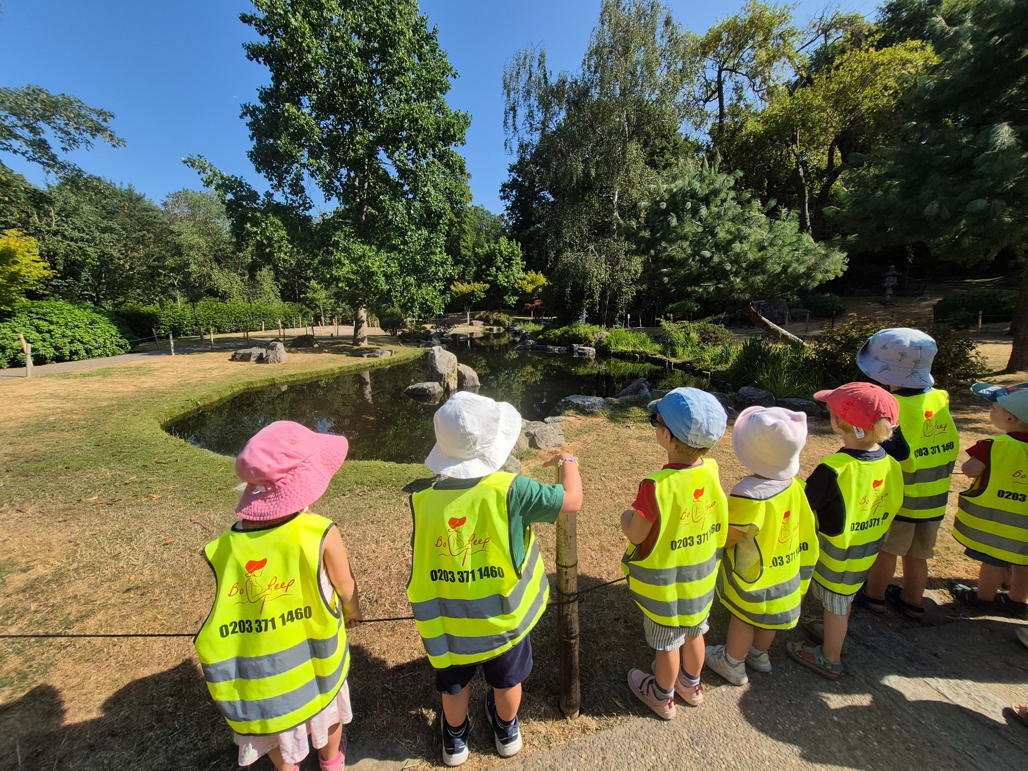 Bo Peep nursery children exploring a garden pond on an outdoor learning visit